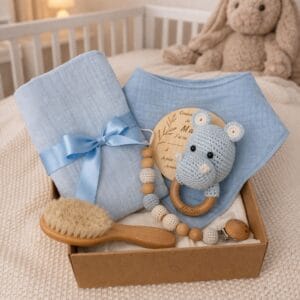 Coffret cadeau naissance personnalisé pour garçon avec hochet hippopotame, lange bleu, bavoir, attache tétine, brosse bébé et carte de naissance.