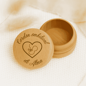 Boîte à cordon ombilical personnalisée avec le prénom Alma, en bois gravé, présentée ouverte sur une texture crème douce.